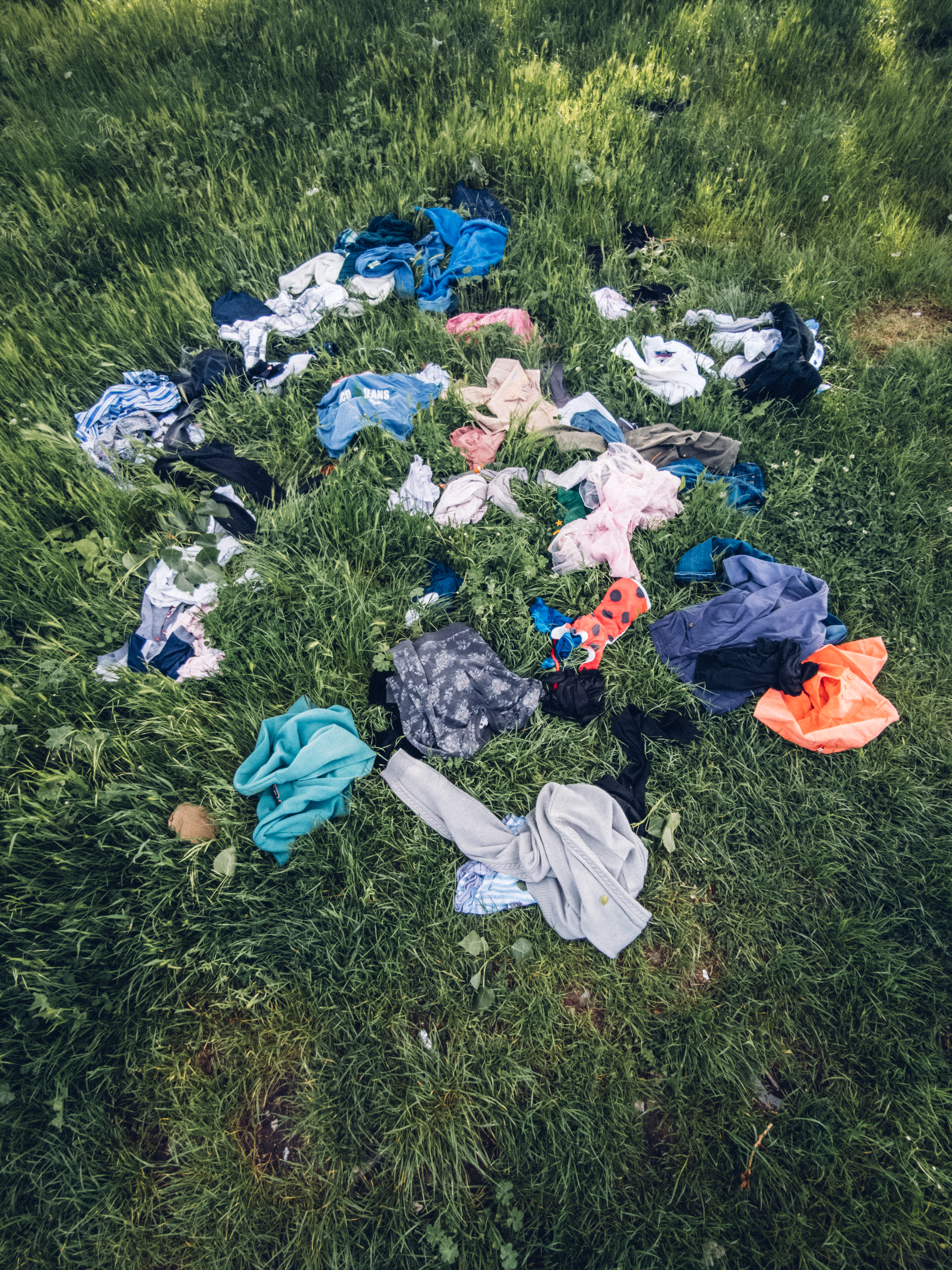 Clothes thrown in the grass field